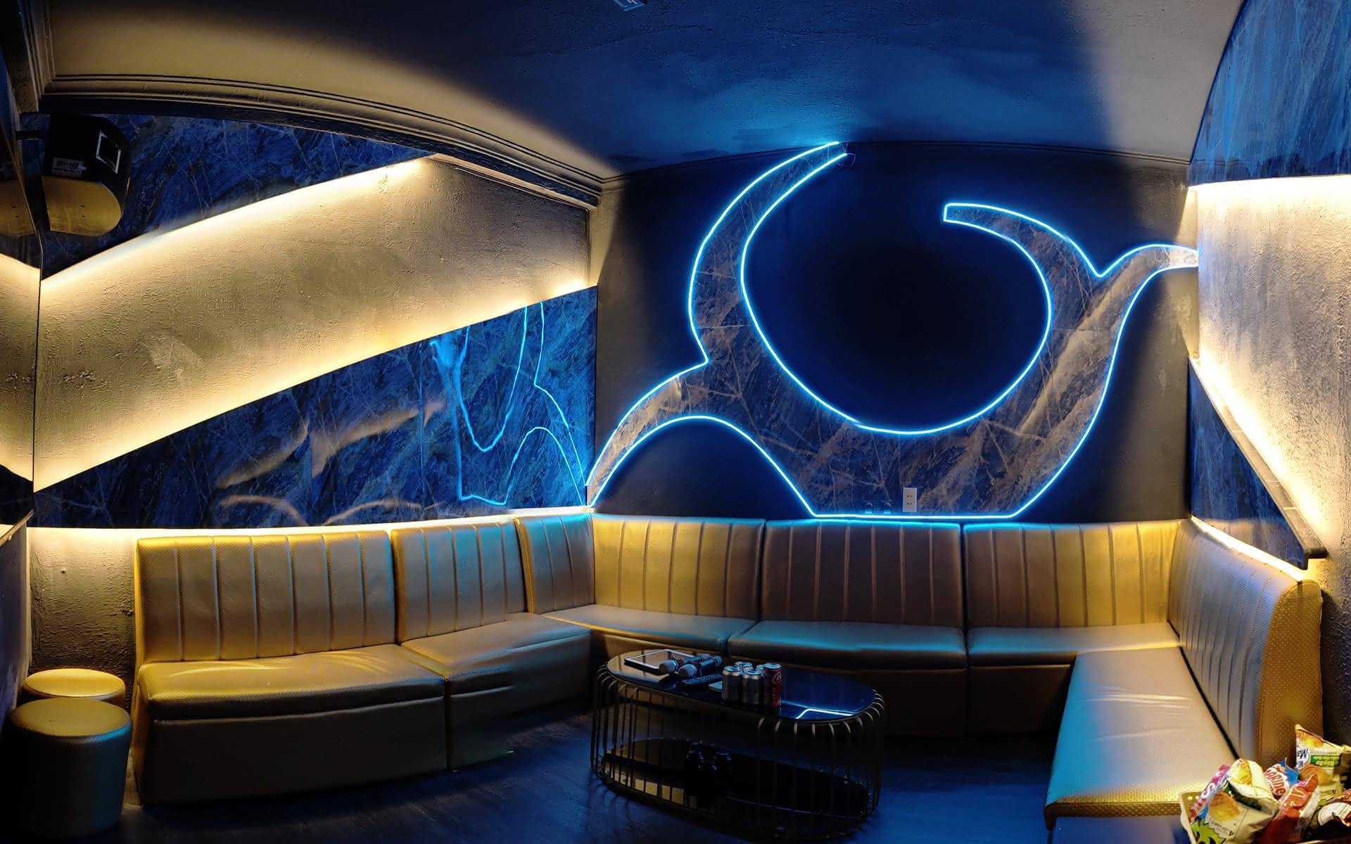 VIP karaoke room at Barbie Bar with banquette seating under neon.