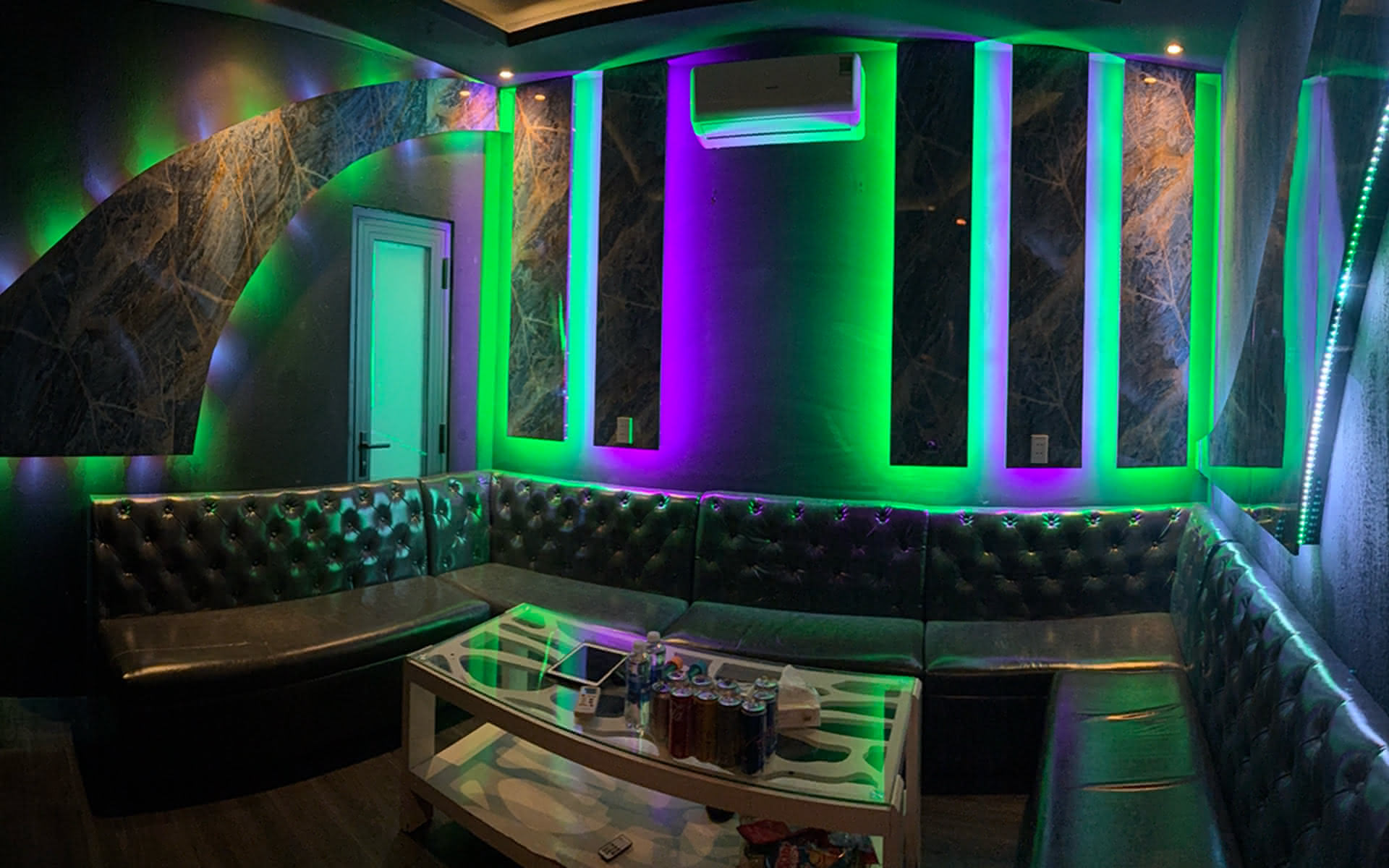 Second VIP karaoke room at Barbie Bar, lit in green and violet neon.